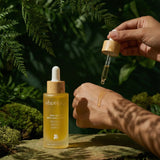 Shveta labs skincare dropper bottle with a hand holding a dropper over a natural background